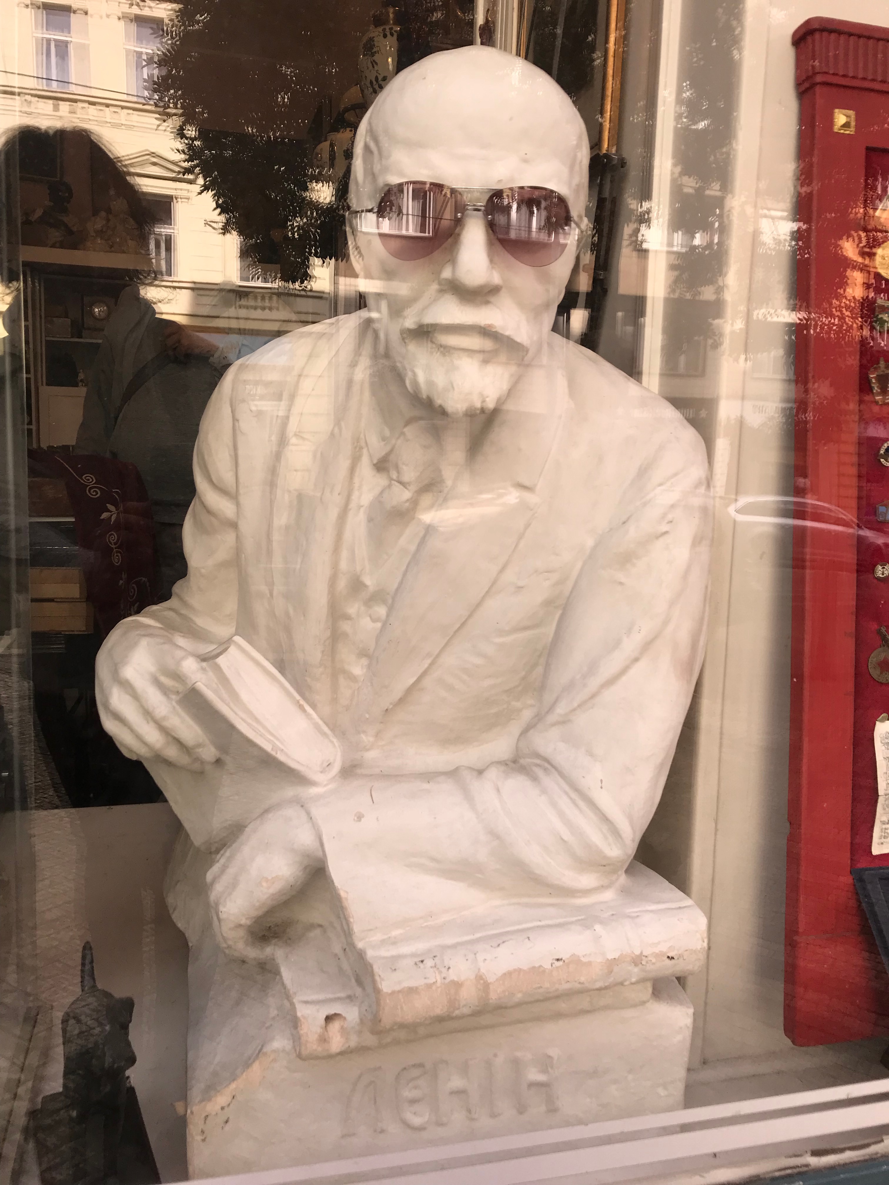 Image 8. Sculpture of Lenin wearing sunglasses staying in the window of  antique shop.